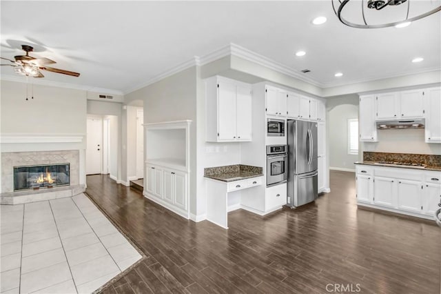 kitchen featuring ceiling fan, stainless steel appliances, hardwood / wood-style floors, white cabinets, and ornamental molding