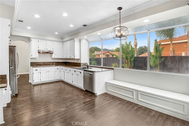 kitchen with dark hardwood / wood-style flooring, white cabinetry, stainless steel appliances, and hanging light fixtures