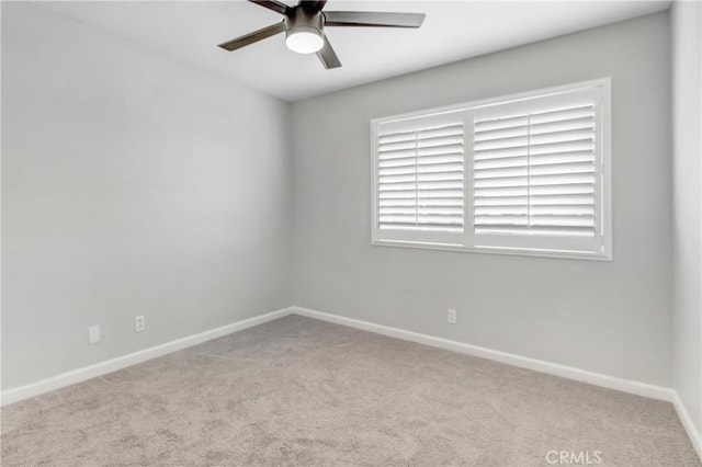 spare room featuring light carpet and ceiling fan