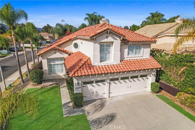 mediterranean / spanish-style home with a garage and a front lawn