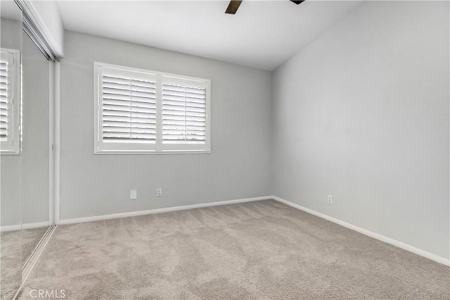 unfurnished bedroom featuring a closet, light colored carpet, and ceiling fan