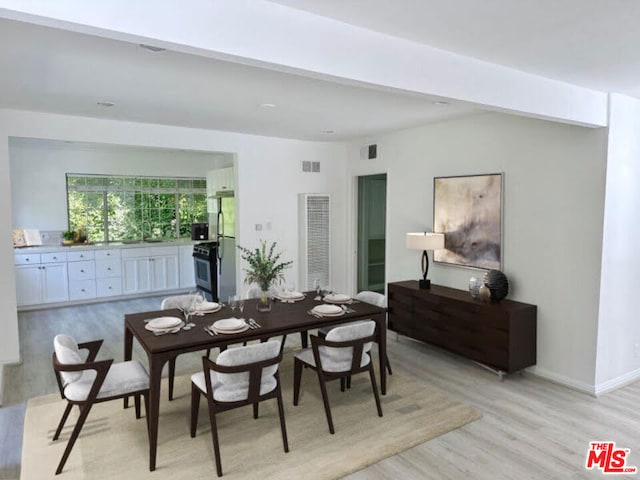 dining room with light hardwood / wood-style floors and sink