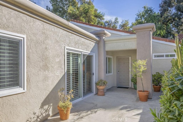 view of exterior entry featuring a patio