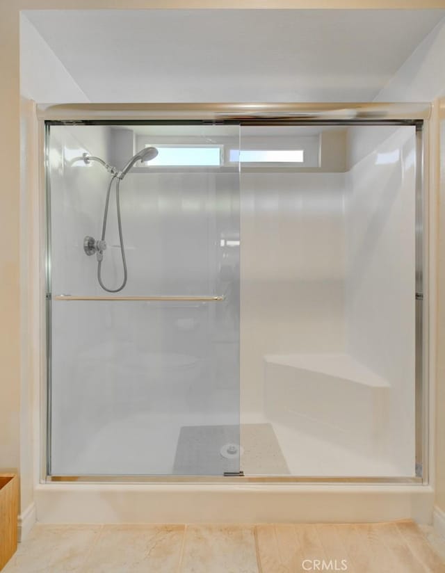 bathroom featuring a shower with door