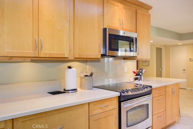 kitchen with appliances with stainless steel finishes and light brown cabinets