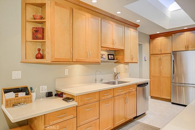 kitchen featuring a skylight, sink, stainless steel appliances, and light brown cabinets