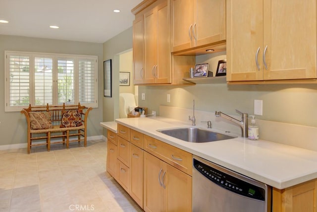 kitchen with light brown cabinetry, light tile patterned floors, stainless steel dishwasher, and sink