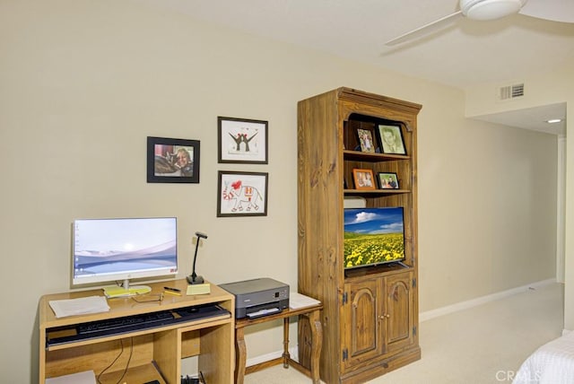 carpeted office space with ceiling fan