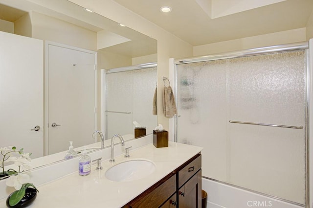 bathroom featuring shower / bath combination with glass door and vanity