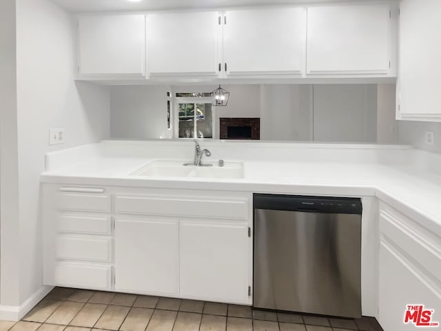 kitchen with light tile patterned flooring, sink, white cabinets, and stainless steel dishwasher