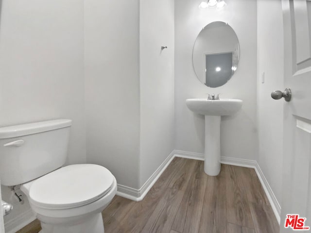 bathroom with toilet and hardwood / wood-style flooring