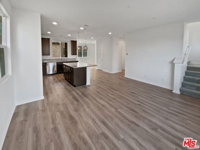 kitchen with hardwood / wood-style flooring, dishwasher, a kitchen island, and dark brown cabinetry