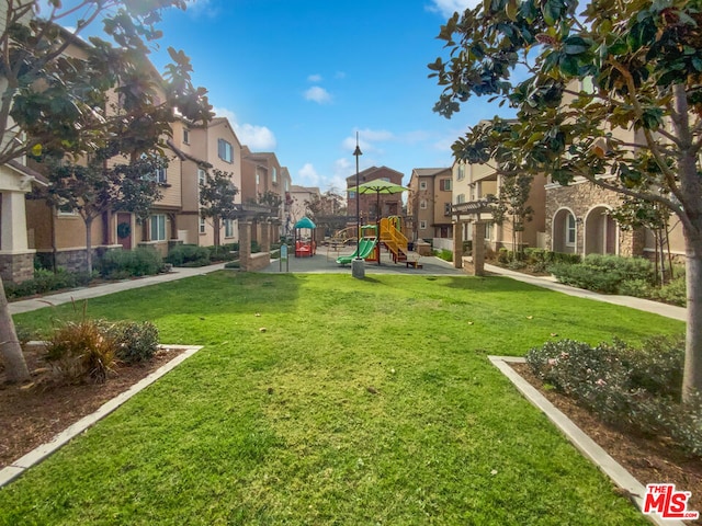 view of property's community with a playground and a lawn