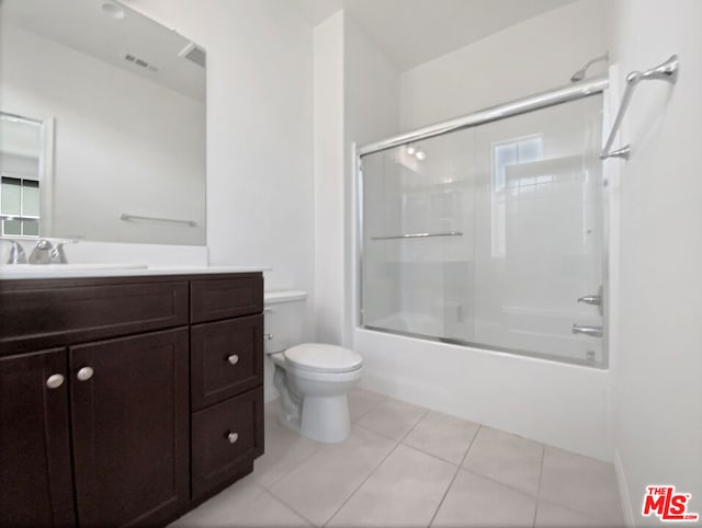 full bathroom with tile patterned flooring, vanity, enclosed tub / shower combo, and toilet