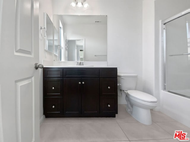 full bathroom with tile patterned flooring, vanity, toilet, and shower / bath combination with glass door