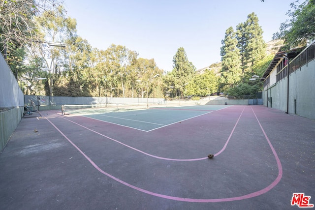 view of tennis court featuring basketball hoop