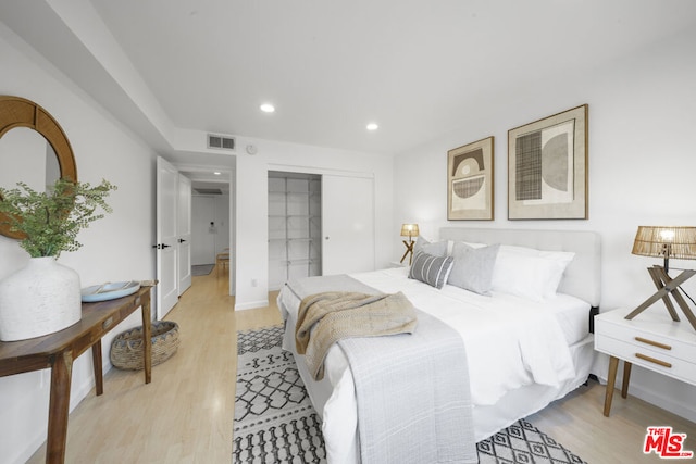 bedroom with light wood-type flooring and a closet