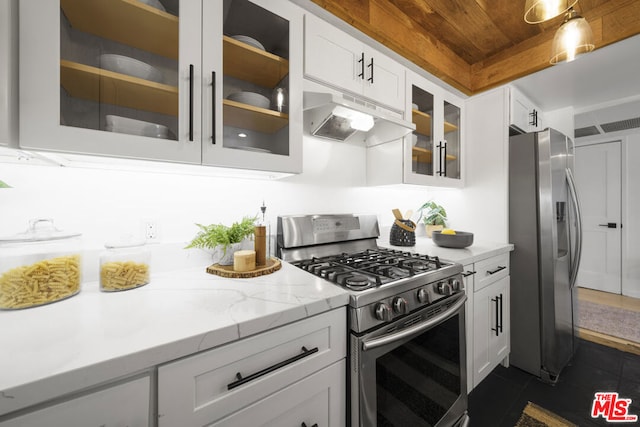 kitchen with light stone counters, white cabinets, and appliances with stainless steel finishes