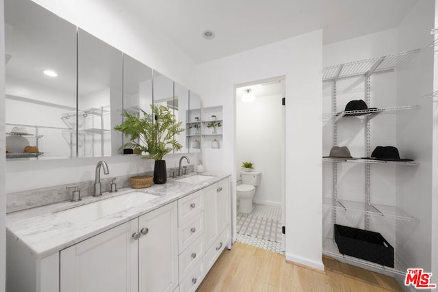 bathroom with hardwood / wood-style floors, toilet, and vanity