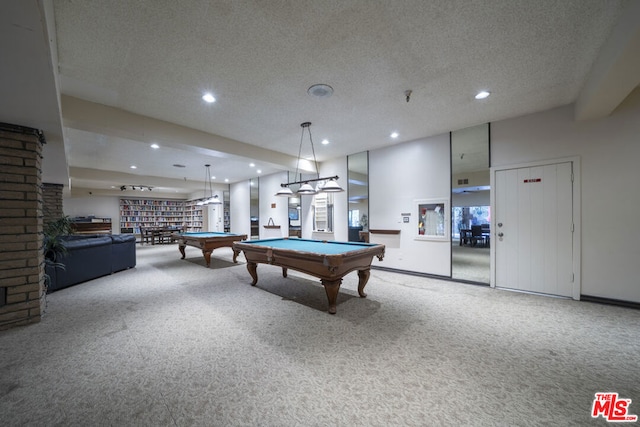 game room featuring a textured ceiling, pool table, and carpet floors