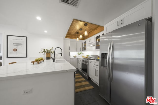 kitchen with pendant lighting, appliances with stainless steel finishes, white cabinetry, sink, and light stone counters