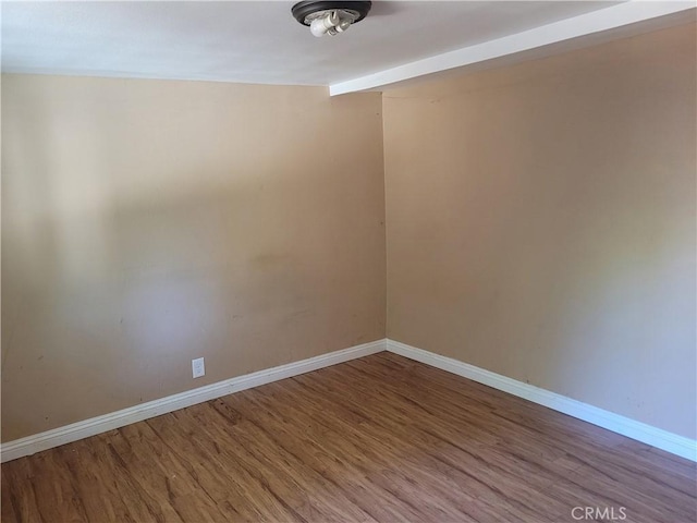 unfurnished room with hardwood / wood-style floors and vaulted ceiling