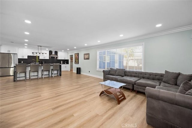 living room with light hardwood / wood-style floors and ornamental molding