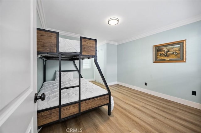 bedroom with crown molding and wood-type flooring