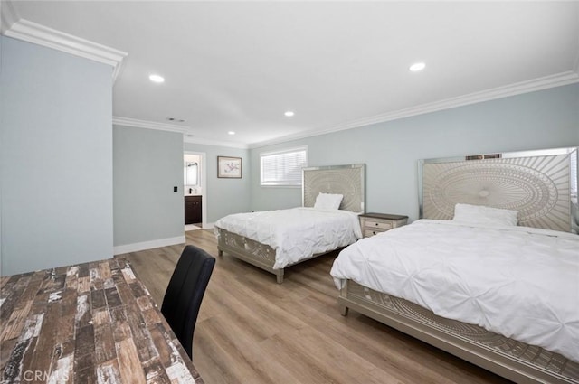 bedroom with light hardwood / wood-style floors, crown molding, and connected bathroom