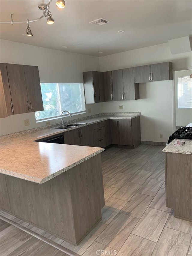 kitchen featuring kitchen peninsula, range, light wood-type flooring, and sink