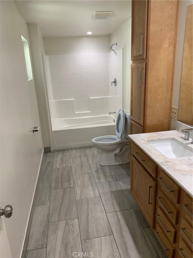 full bathroom featuring vanity, tiled shower / bath combo, and toilet