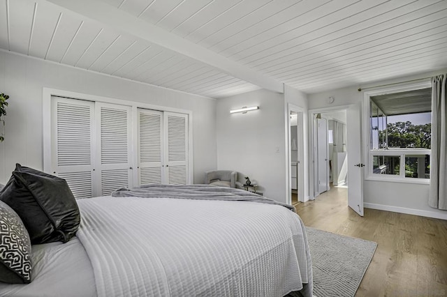 bedroom with beam ceiling, wood ceiling, and light hardwood / wood-style floors