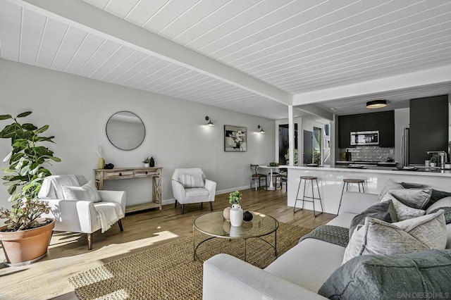 living room with beam ceiling and hardwood / wood-style flooring