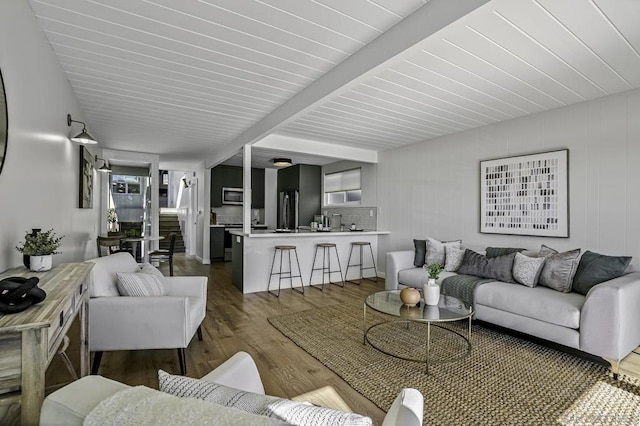 living room with dark hardwood / wood-style floors and beam ceiling