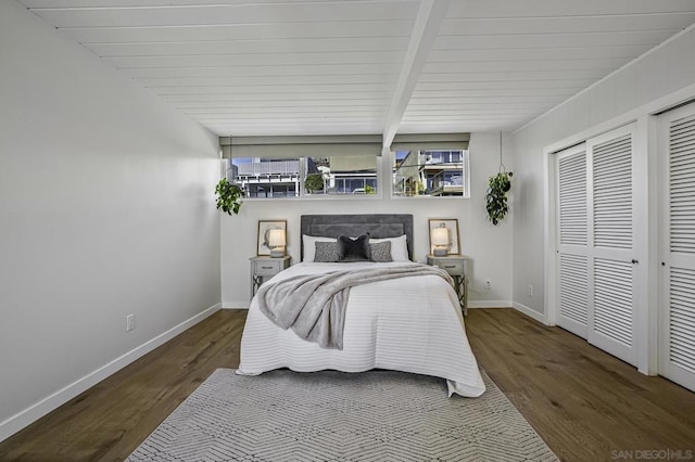 bedroom with beam ceiling and dark hardwood / wood-style flooring