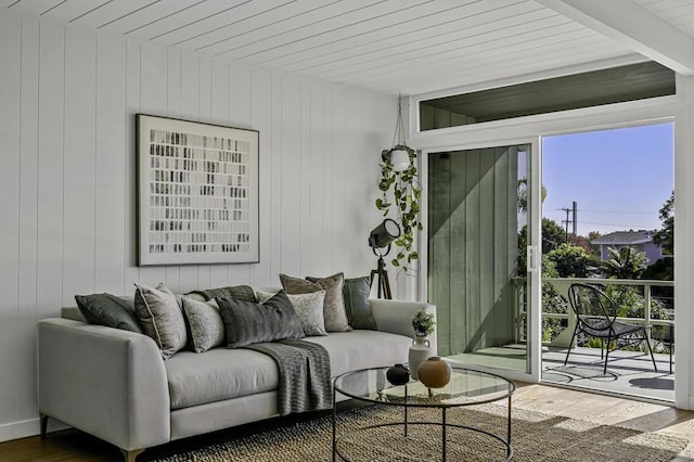 living room with beamed ceiling, wood walls, and hardwood / wood-style floors