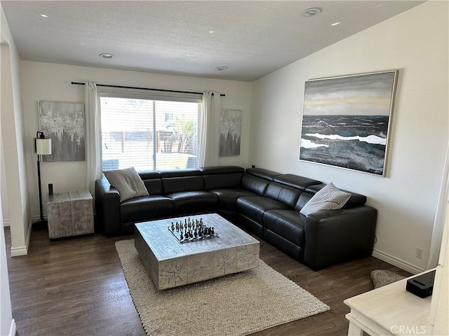 living room with a textured ceiling, dark wood-type flooring, and vaulted ceiling