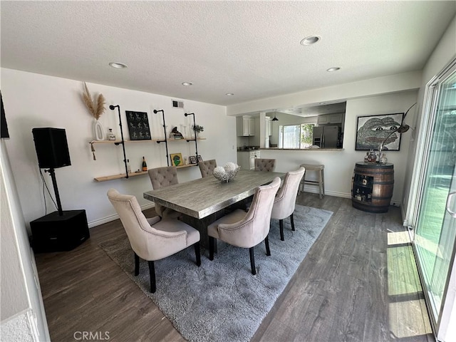 dining space with a textured ceiling and dark wood-type flooring