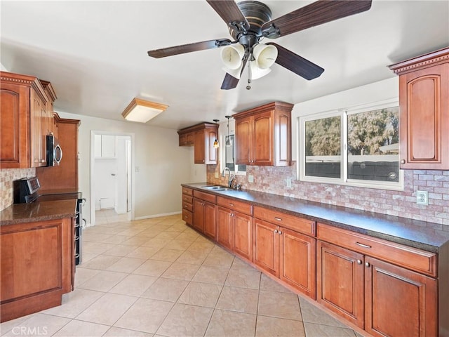 kitchen with decorative backsplash, stainless steel appliances, light tile patterned flooring, and sink