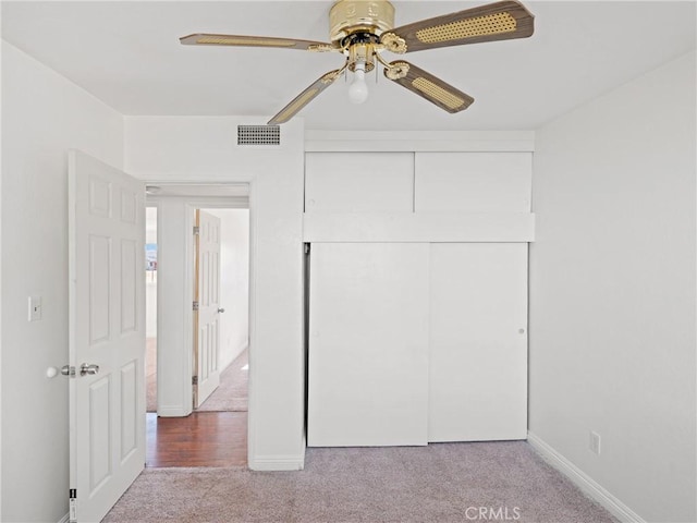 unfurnished bedroom with ceiling fan, a closet, and light colored carpet