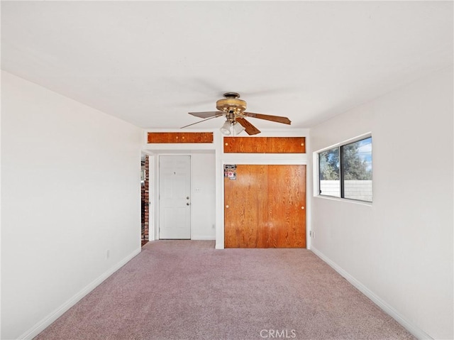 empty room featuring ceiling fan and carpet