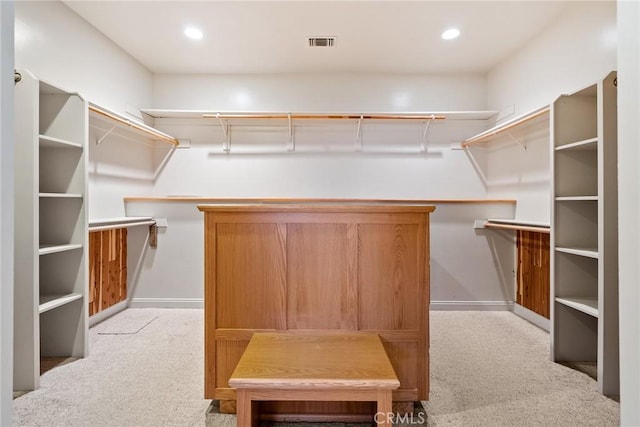 walk in closet featuring light colored carpet