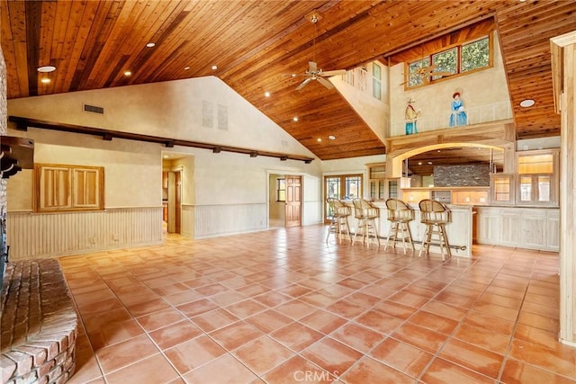 tiled living room with ceiling fan, a healthy amount of sunlight, wood ceiling, and high vaulted ceiling