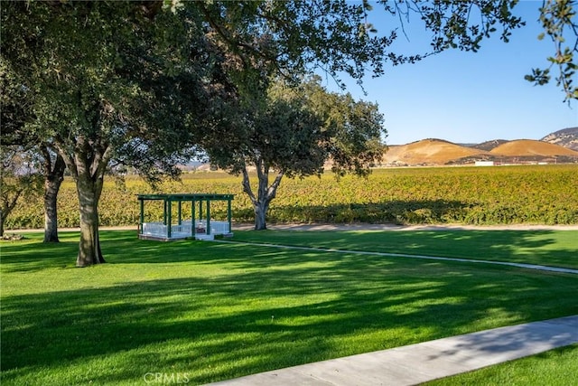 surrounding community with a mountain view and a yard