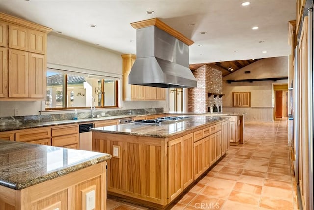 kitchen with dark stone counters, island range hood, vaulted ceiling, a kitchen island, and stainless steel gas cooktop