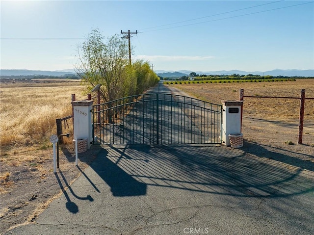 view of gate featuring a mountain view and a rural view