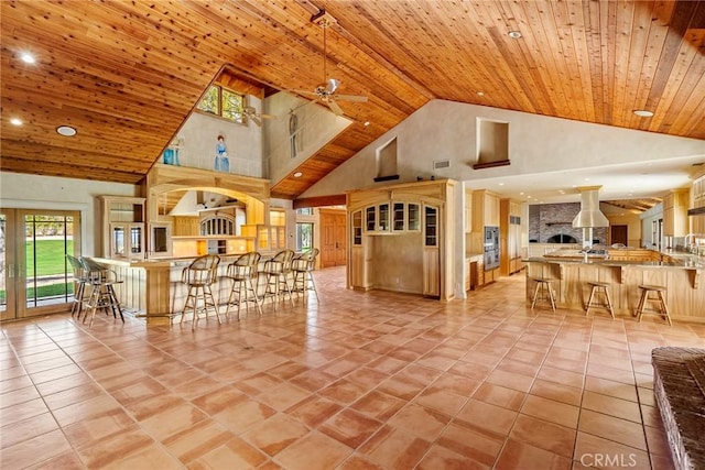 unfurnished living room with ceiling fan, high vaulted ceiling, wood ceiling, and light tile patterned floors