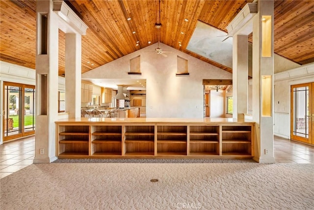 kitchen featuring ceiling fan, high vaulted ceiling, range hood, kitchen peninsula, and light tile patterned floors