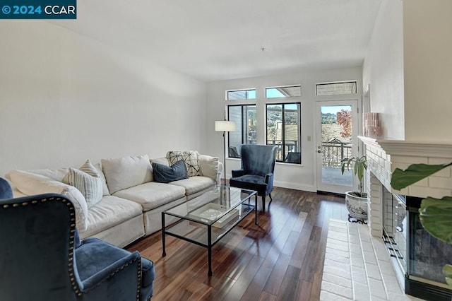 living room with wood-type flooring and a brick fireplace