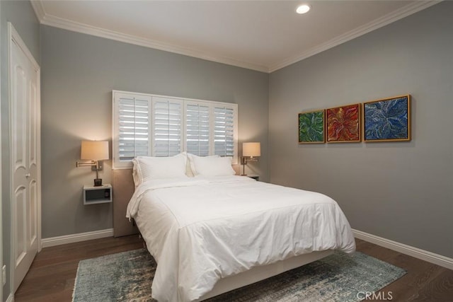 bedroom featuring dark hardwood / wood-style floors, crown molding, and a closet